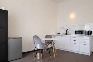 a kitchen with two chairs and a table and a microwave at Hotel Mazowiecki WOW in Warsaw