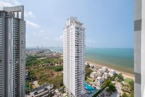 an aerial view of a tall white building next to a beach at 2BR Family Condo - Veranda Pattaya - Beachfront in Na Jomtien