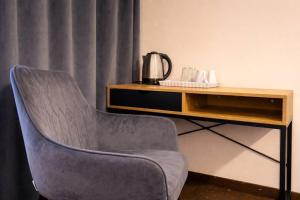 a chair sitting next to a table with a coffee maker at Hotel Mazowiecki WOW in Warsaw