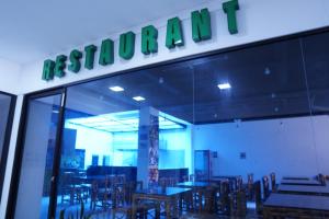 a restaurant with tables and chairs and a sign on the window at Hotel Gool De Guerron in Quito