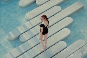 a woman in a black bathing suit standing on some surfboards at 2BR Family Condo - Veranda Pattaya - Beachfront in Na Jomtien