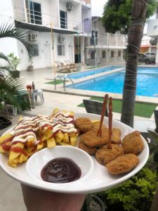a plate of food with cookies and dipping sauce at Casa de Huéspedes Playas Arena in Playas