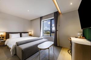 a hotel room with a bed and a window at Daegu Hound Hotel Dongchon Amusement Park in Daegu