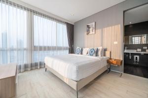 a bedroom with a large bed and a large window at Large 3BR Veranda Pattaya Direct Beach Access in Jomtien Beach +28 photos