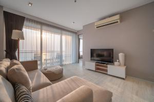 a living room with a couch and a flat screen tv at Large 3BR Veranda Pattaya Direct Beach Access in Jomtien Beach