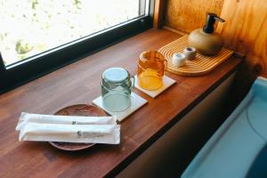 a table with two glasses of orange juice and a bottle at ふなだけの家 in Shinano