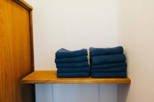 two blue towels sitting on a wooden shelf at ふなだけの家 in Shinano +15 photos