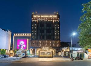 a building with a sign on top of it at night at Ratan International in Pondicherry