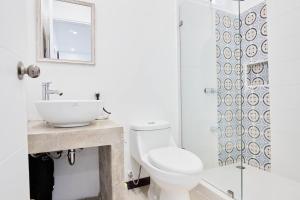 a bathroom with a toilet and a sink and a shower at Butterfly House - Centric 2BR with shared pool in Puerto Viejo +14 photos