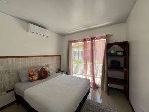 a bedroom with a bed and a window at Butterfly House - Centric 2BR with shared pool in Puerto Viejo