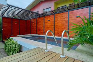 a swimming pool next to a house with a wooden fence at Sloth House - Centric 2BR with shared pool in Puerto Viejo