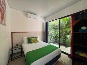 a bedroom with a bed and a large window at Sloth House - Centric 2BR with shared pool in Puerto Viejo +18 photos
