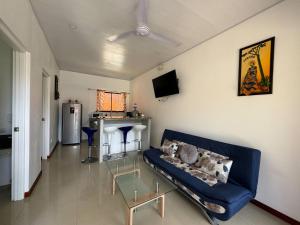 a living room with a blue couch and a table at Sloth House - Centric 2BR with shared pool in Puerto Viejo
