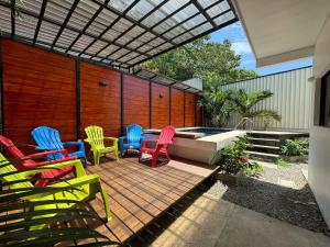 a patio with colorful chairs and a swimming pool at Sloth House - Centric 2BR with shared pool in Puerto Viejo