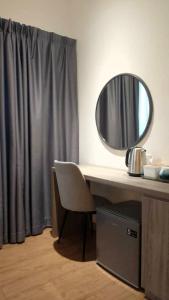 a mirror sitting on top of a desk with a chair at Wafiq Studio in Kota Bharu +2 photos