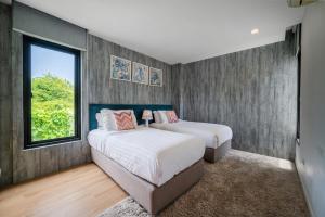 a bedroom with two beds and a window at Movenpick Residences 4-Bedroom Pool Villa Beach Access, Na Jomtien Pattaya in Na Jomtien +25 photos