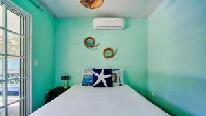 a bedroom with a bed with a blue wall at Casa Caribe Azul - Playa Negra 2BR with AC and pool in Puerto Viejo +39 photos
