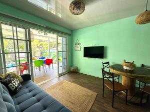 a living room with a blue couch and a table at Casa Caribe Azul - Playa Negra 2BR with AC and pool in Puerto Viejo