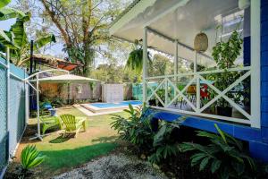 a backyard with a swimming pool and a house at Casa Caribe Azul - Playa Negra 2BR with AC and pool in Puerto Viejo