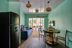 a kitchen and living room with a refrigerator and a table at Casa Caribe Azul - Playa Negra 2BR with AC and pool in Puerto Viejo