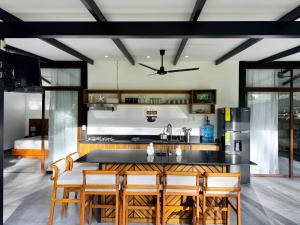 a kitchen with a table and some chairs at Sharka House - Playa Negra 2BR with pool & AC in Puerto Viejo