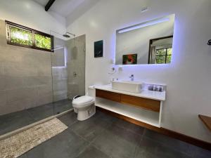 a bathroom with a toilet and a sink and a shower at Sharka House - Playa Negra 2BR with pool & AC in Puerto Viejo +10 photos