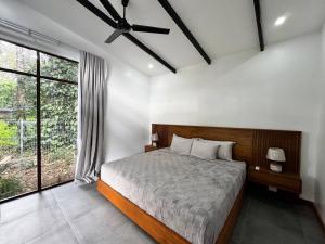 a bedroom with a bed and a ceiling fan at Sharka House - Playa Negra 2BR with pool & AC in Puerto Viejo