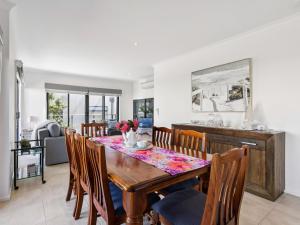 a kitchen and dining room with a wooden table and chairs at Azura on Gordon in Mornington
