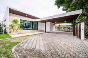 an image of a house with a stone driveway at Movenpick Residences 4-Bedroom Pool Villa Beach Access, Na Jomtien Pattaya in Na Jomtien