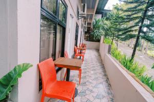 a patio with orange chairs and a wooden table at Serenity Busay Room 1 in Cebu City