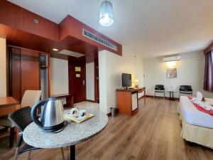a hotel room with a bed and a table in a room at Hatyai Golden Crown Hotel in Hat Yai