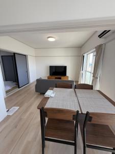 a living room with a table and a couch at OtowaBase in Kofu