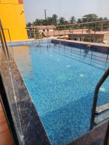 a large swimming pool with blue water at Paromita inn in Tajpur