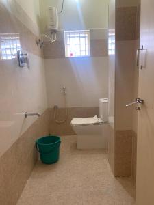 a bathroom with a toilet and a bucket at KH Residency And Lodging in Punganūru +14 photos