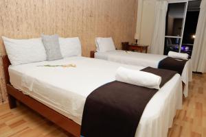 a hotel room with two beds and a window at Irigoin Hospedaje in Nueva Cajamarca