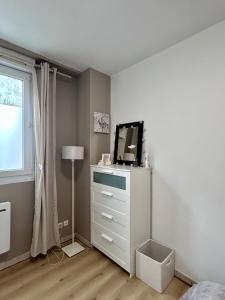 a bedroom with a dresser with a television on it at Le Petit Cocon de Pleyben in Pleyben