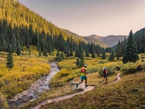 two people running on a trail near a river at Aspenwood - CoralTree Residence Collection in Snowmass Village