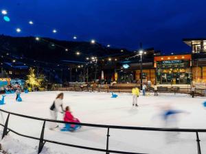 a group of people skating on an ice rink at night at Aspenwood - CoralTree Residence Collection in Snowmass Village +19 photos