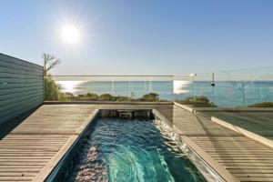 a swimming pool on a deck with a view of the ocean at The Veranda - Panoramic Bay Views Private Beach Access Pool in Mount Eliza