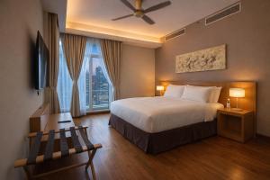 a hotel room with a bed and a window at Cormar Suites Kuala Lumpur in Kuala Lumpur