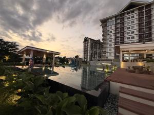 a hotel with a pool in front of a building at The Infinity View in Talisay