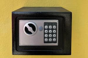 a black and silver remote control on a yellow wall at Quarto econômico Centro Itajai in Itajaí
