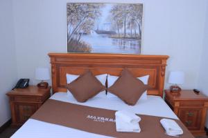 a bedroom with a bed with a painting on the wall at Maximum Hotel in Navoi +69 photos