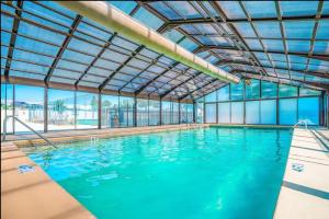 a large indoor swimming pool with blue water at Pointe Royale's Relaxation Pointe in Branson