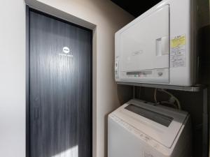 a small kitchen with a washer and dryer and a microwave at Yufuin Covaco in Yufu