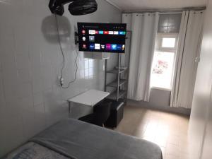 a hospital room with a bed and a tv at Quarto econômico Centro Itajai in Itajaí