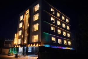 a tall building with lit up windows at night at Hotel Royal Dot, Haridwar in Haridwār +39 photos
