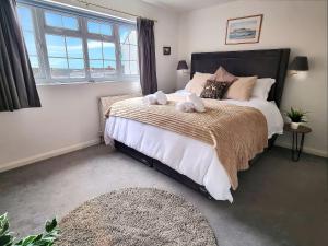 a bedroom with a large bed with two stuffed animals on it at 3 Leycester Court in Warwick