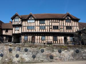 a large wooden building with a stone wall at 3 Leycester Court in Warwick