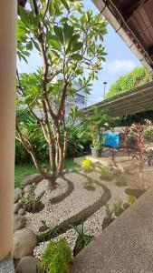 a garden with a tree in the middle at Sentosa Lodge in Padang
